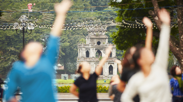 Morning in Hanoi - Point Comfort Group People practice Tai Chi near Hoan Kiem lake with the Turtle Tower in Hanoi.